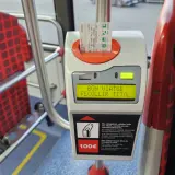 Validando billete para prendre le bus a Barcelone. Asientos rojos con patrón de cuadros en el interior del autobús.