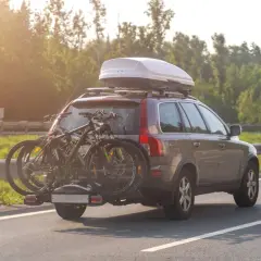 Turismo con portabicicletas y cofre de techo. La carga sobresale bastante, ideal para viajes largos.