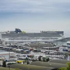Un enorme crucero "EPIC" en el puerto de Barcelona, con barcos de carga y contenedores.
