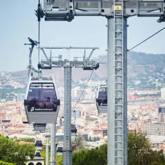 El teleférico de Montjuïc ofrece vistas panorámicas de Barcelona. Varias cabinas se deslizan sobre la ciudad, conectando puntos clave.