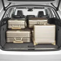 Maletero de coche con cuatro maletas doradas. Se puede llevar carga con los asientos abatidos, ideal para viajes largos.