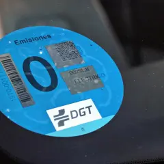 Etiqueta DGT "0 emisiones" en parabrisas. Los coches con etiqueta 0 pagan zona azul.