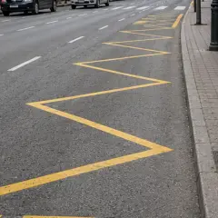 Zigzag amarillo en la carretera, parte de las marcas viales, indica una zona de prohibición de estacionamiento.