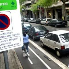 Zona verte Barcelona domingo: señal de estacionamiento, ciclista y coches aparcados en la calle.