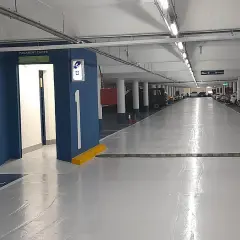 Entrada al parking Rius i Taulet. Pasillo con coches aparcados y señalización de salida.