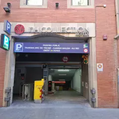 Entrada a parking público en Barcelona, cerca del Arc de Triomf. Carteles indican "NH Collection Hotels" y "parking 24h".