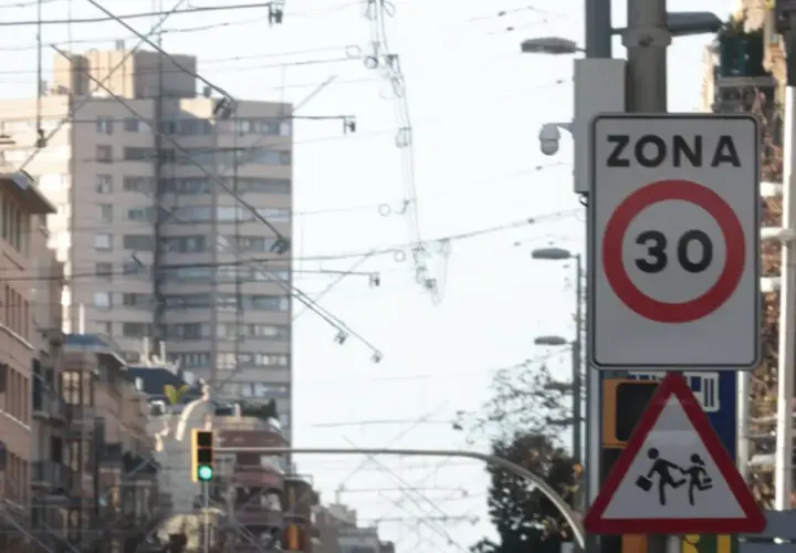 Señal de zona 30 en Barcelona, con un pictograma de niños cruzando. Vigilancia de radares en la ciudad.