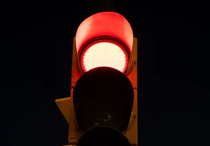 Semaforo con una luz roja intermitente, indicando alto.