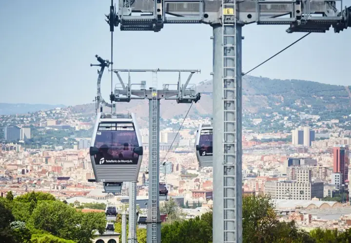 El teleférico de Montjuïc ofrece vistas panorámicas de Barcelona. Varias cabinas se deslizan sobre la ciudad, conectando puntos clave.
