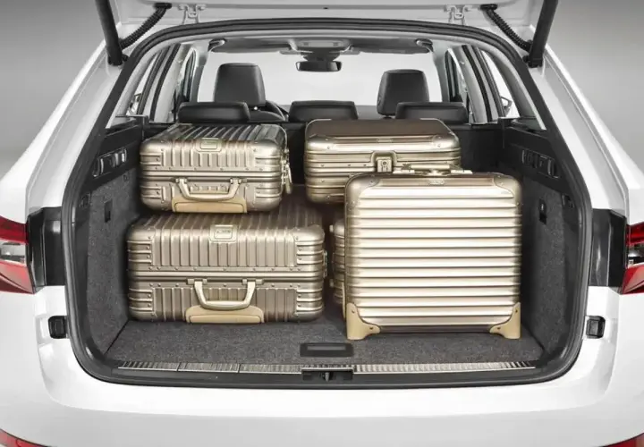 Maletero de coche con cuatro maletas doradas. Se puede llevar carga con los asientos abatidos, ideal para viajes largos.