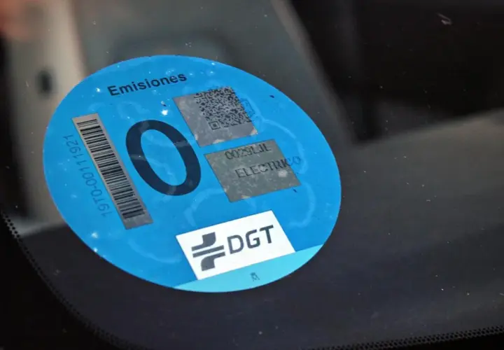 Etiqueta DGT "0 emisiones" en parabrisas. Los coches con etiqueta 0 pagan zona azul.