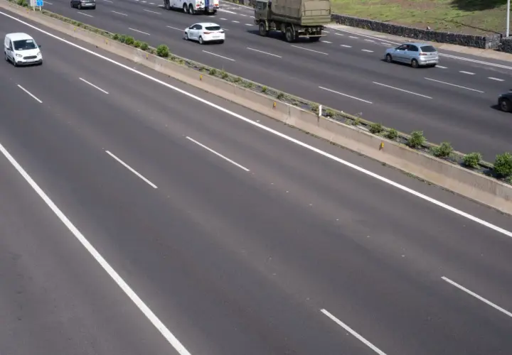 Autopista con varios carriles y vehículos. La **marca transversal discontinua** indica la separación entre ellos.