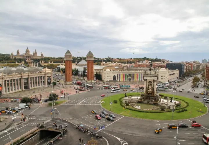 Vista aérea de la Plaza de España en Barcelona, con el Palacio Nacional al fondo y el tráfico circulando. Un buen lugar para dejar el coche, un parking relais Barcelona.