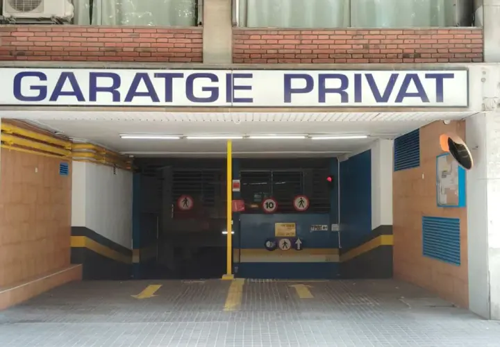 Entrada al parking nn Rocafort Barcelona. Señal de garaje privado con flechas amarillas indicando la dirección.