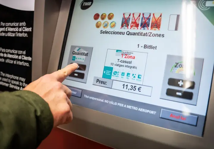 Dedo tocando pantalla para comprar billete T-casual de zona 1 en Barcelona.