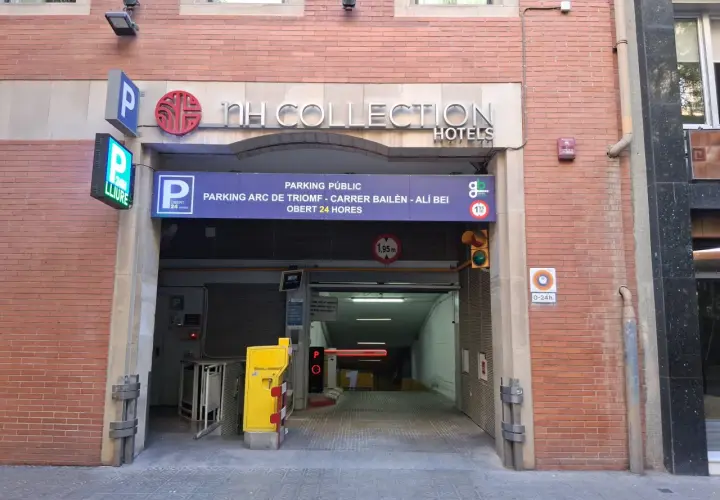 Entrada a parking público en Barcelona, cerca del Arc de Triomf. Carteles indican "NH Collection Hotels" y "parking 24h".