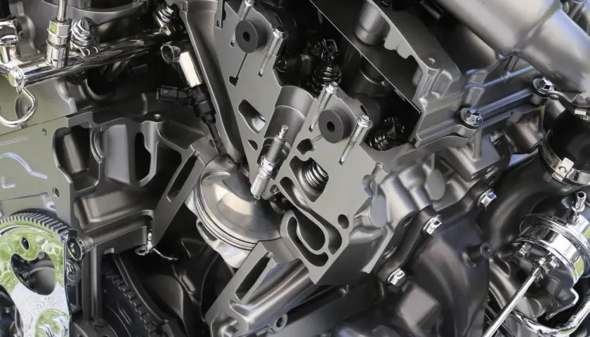 Corte de un motor atmosférico mostrando pistón, bujía y válvulas.