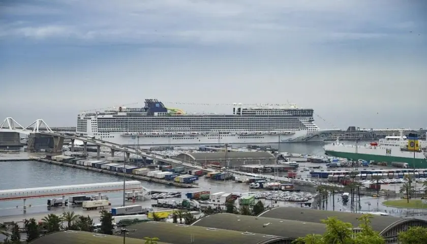 Un enorme crucero "EPIC" en el puerto de Barcelona, con barcos de carga y contenedores.