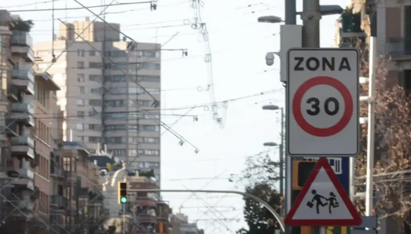 Señal de zona 30 en Barcelona, con un pictograma de niños cruzando. Vigilancia de radares en la ciudad.
