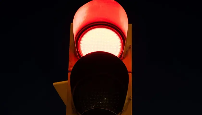 Semaforo con una luz roja intermitente, indicando alto.