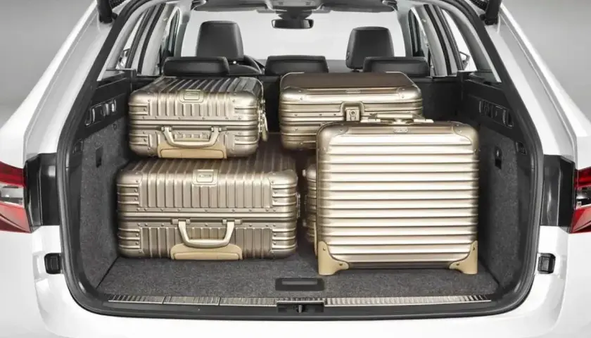 Maletero de coche con cuatro maletas doradas. Se puede llevar carga con los asientos abatidos, ideal para viajes largos.