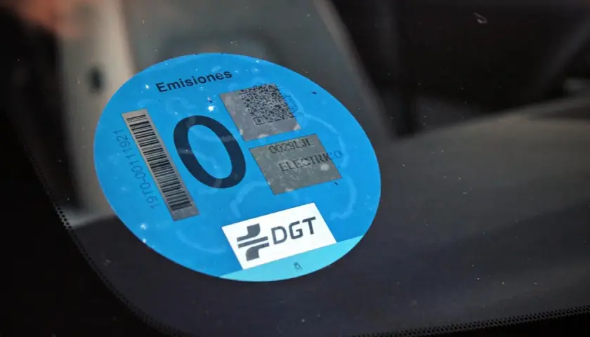Etiqueta DGT "0 emisiones" en parabrisas. Los coches con etiqueta 0 pagan zona azul.