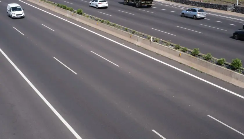Autopista con varios carriles y vehículos. La **marca transversal discontinua** indica la separación entre ellos.