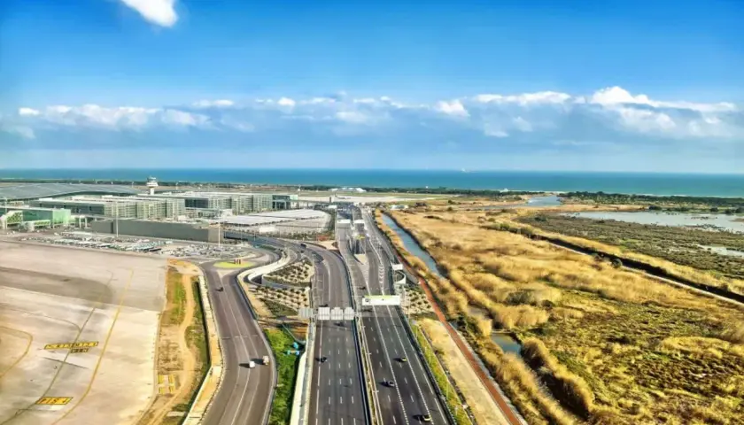 Vista aérea del aeropuerto de Barcelona, con el aena parking Barcelona T2, autopista y mar al fondo.