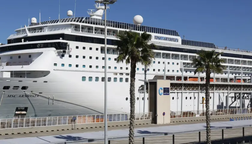 El crucero MSC Armonia atracado en la terminal de cruceros Barcelona, con palmeras y cielo azul.