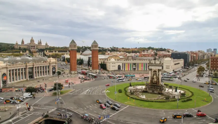 Vista aérea de la Plaza de España en Barcelona, con el Palacio Nacional al fondo y el tráfico circulando. Un buen lugar para dejar el coche, un parking relais Barcelona.