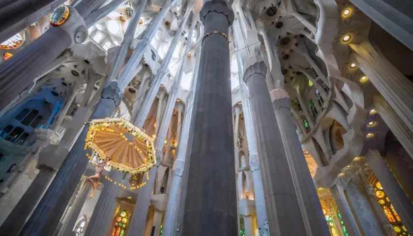 Interior de la Sagrada Familia, con columnas que se elevan hacia el techo abovedado. Descubre cómo llegar a la Sagrada Familia en metro.