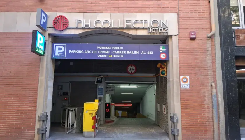 Entrada a parking público en Barcelona, cerca del Arc de Triomf. Carteles indican "NH Collection Hotels" y "parking 24h".