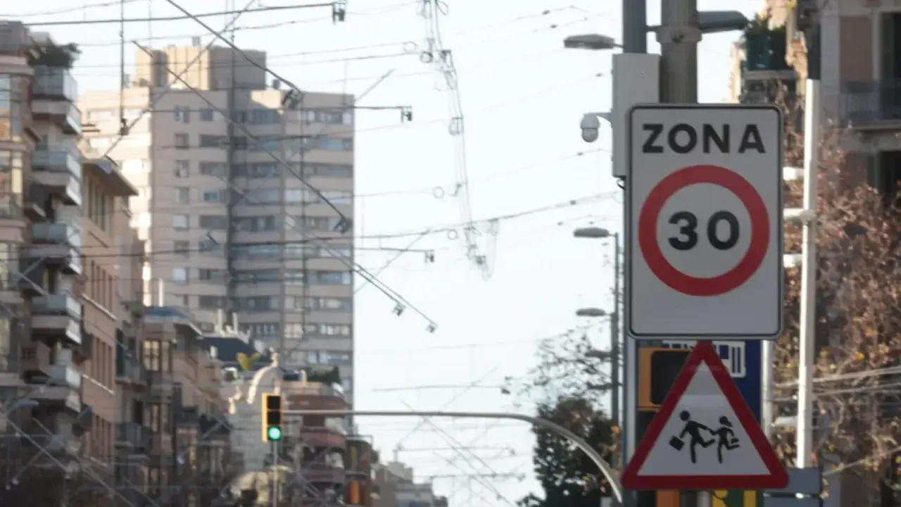 Señal de zona 30 en Barcelona, con un pictograma de niños cruzando. Vigilancia de radares en la ciudad.