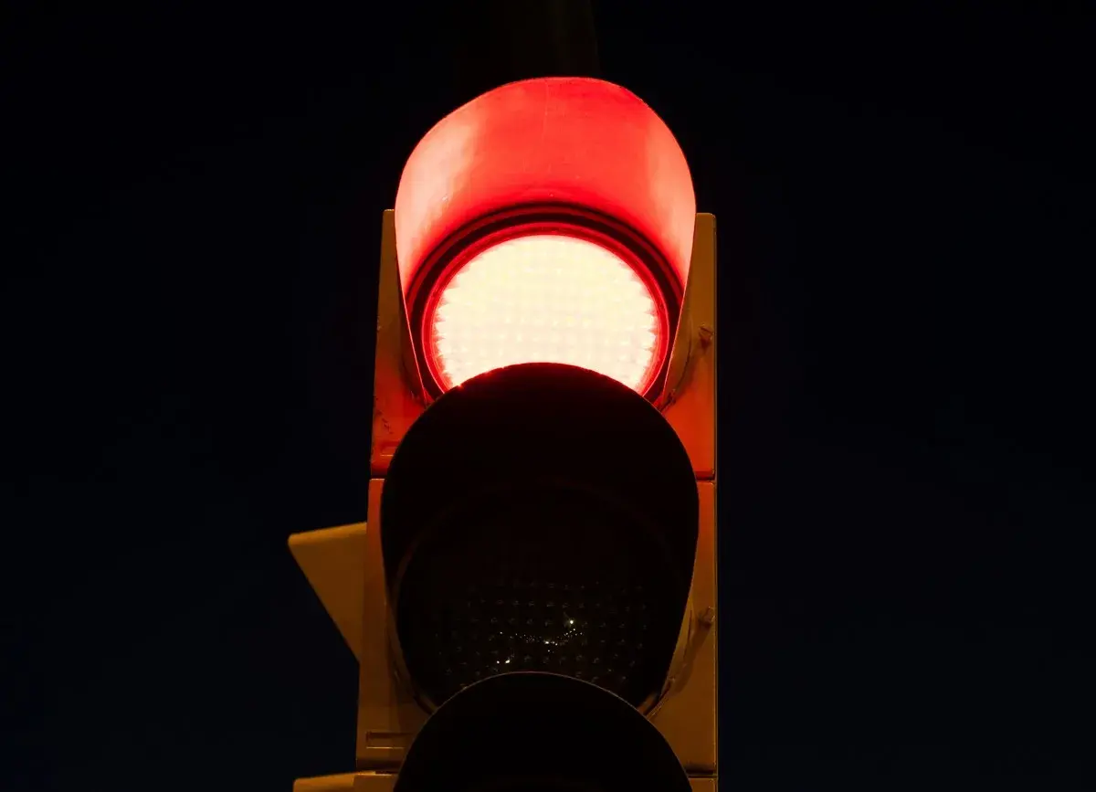 Semaforo con una luz roja intermitente, indicando alto.