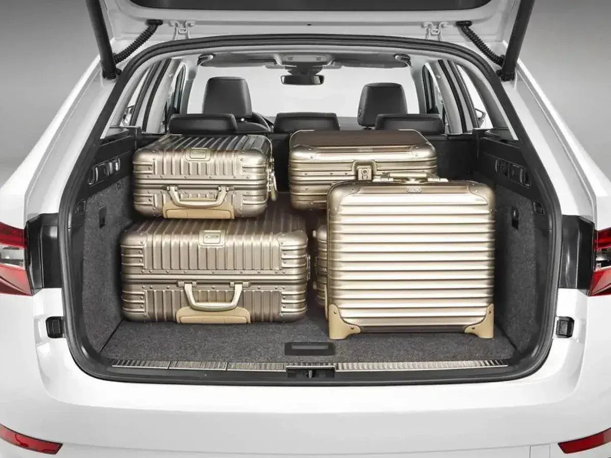 Maletero de coche con cuatro maletas doradas. Se puede llevar carga con los asientos abatidos, ideal para viajes largos.
