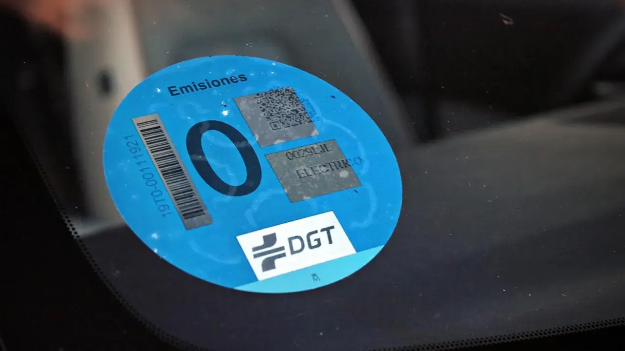 Etiqueta DGT "0 emisiones" en parabrisas. Los coches con etiqueta 0 pagan zona azul.