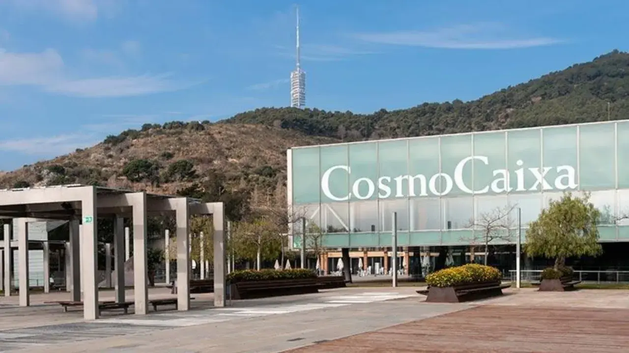Edificio CosmoCaixa Barcelona con torre de telecomunicaciones al fondo y zona ajardinada.
