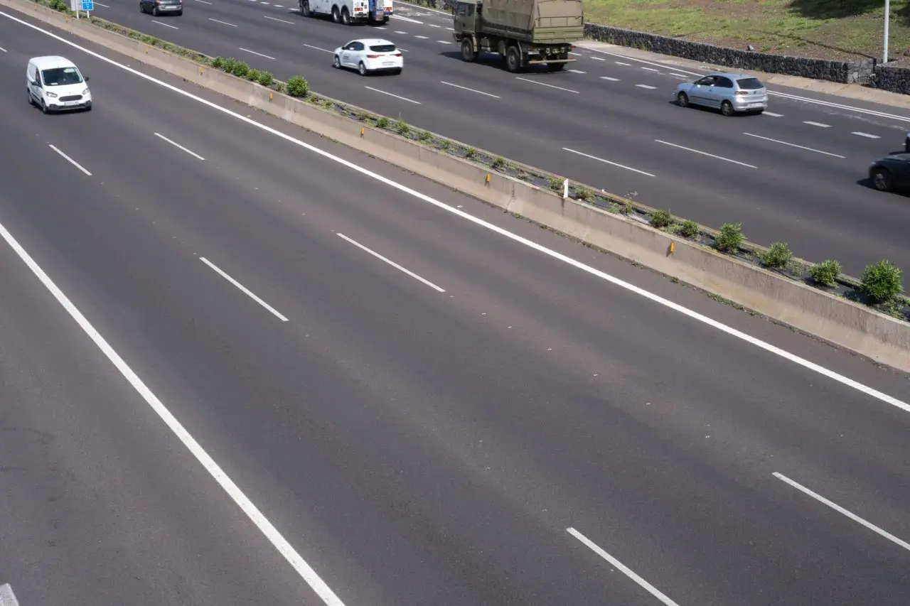 Autopista con varios carriles y vehículos. La **marca transversal discontinua** indica la separación entre ellos.
