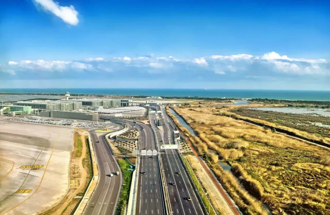 Vista aérea del aeropuerto de Barcelona, con el aena parking Barcelona T2, autopista y mar al fondo.