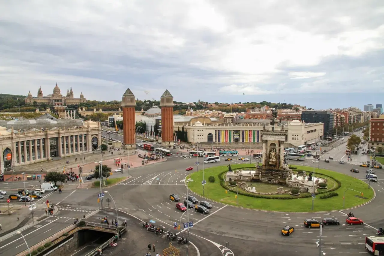 Vista aérea de la Plaza de España en Barcelona, con el Palacio Nacional al fondo y el tráfico circulando. Un buen lugar para dejar el coche, un parking relais Barcelona.