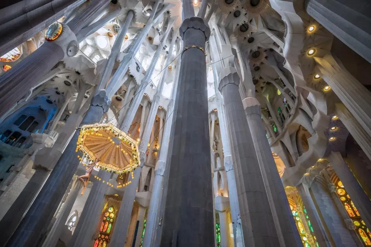 Interior de la Sagrada Familia, con columnas que se elevan hacia el techo abovedado. Descubre cómo llegar a la Sagrada Familia en metro.