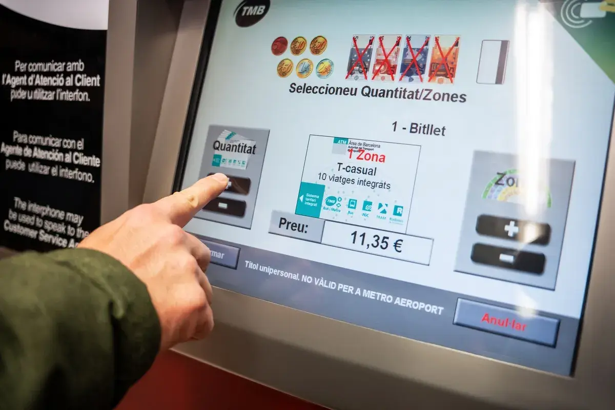 Dedo tocando pantalla para comprar billete T-casual de zona 1 en Barcelona.