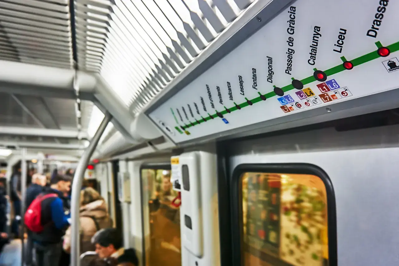 Mapa del metro de Barcelona, con el "Passeig de Gràcia" destacado. Viajeros en el vagón.
