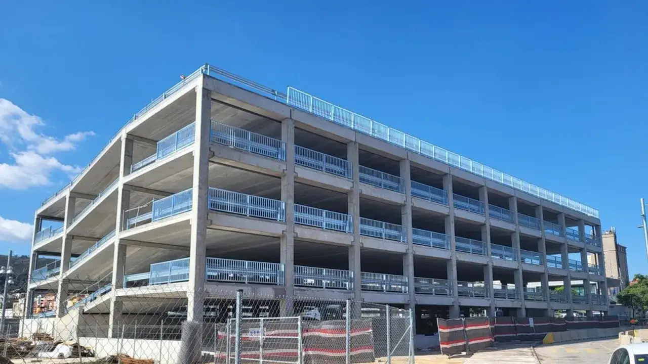 Nuevo parking relais en Barcelona, estructura de hormig&oacute;n de varias plantas con barandillas met&aacute;licas y vistas al cielo azul.