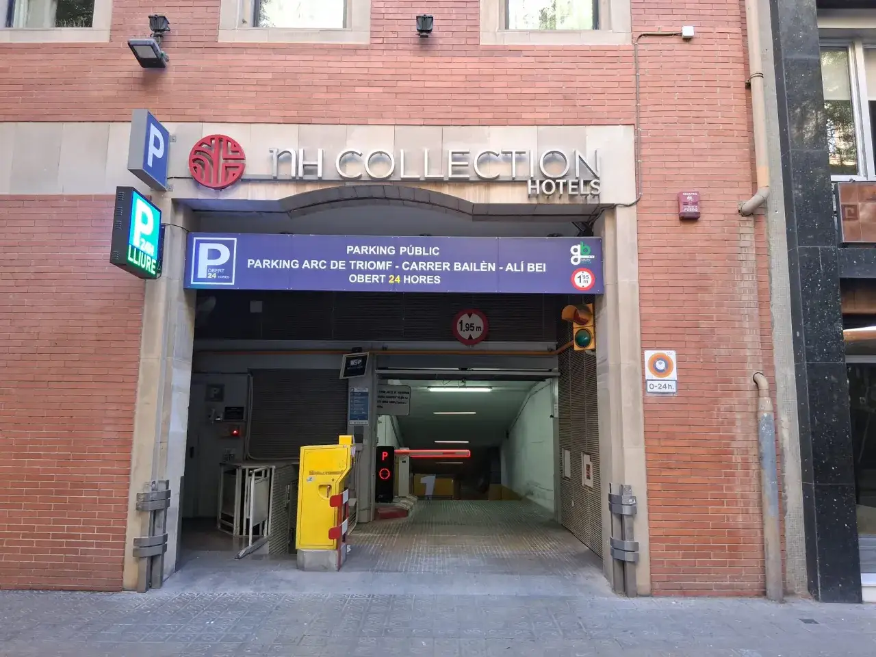 Entrada a parking público en Barcelona, con señalización de NH Collection Hotels y altura máxima de 1.95m.
