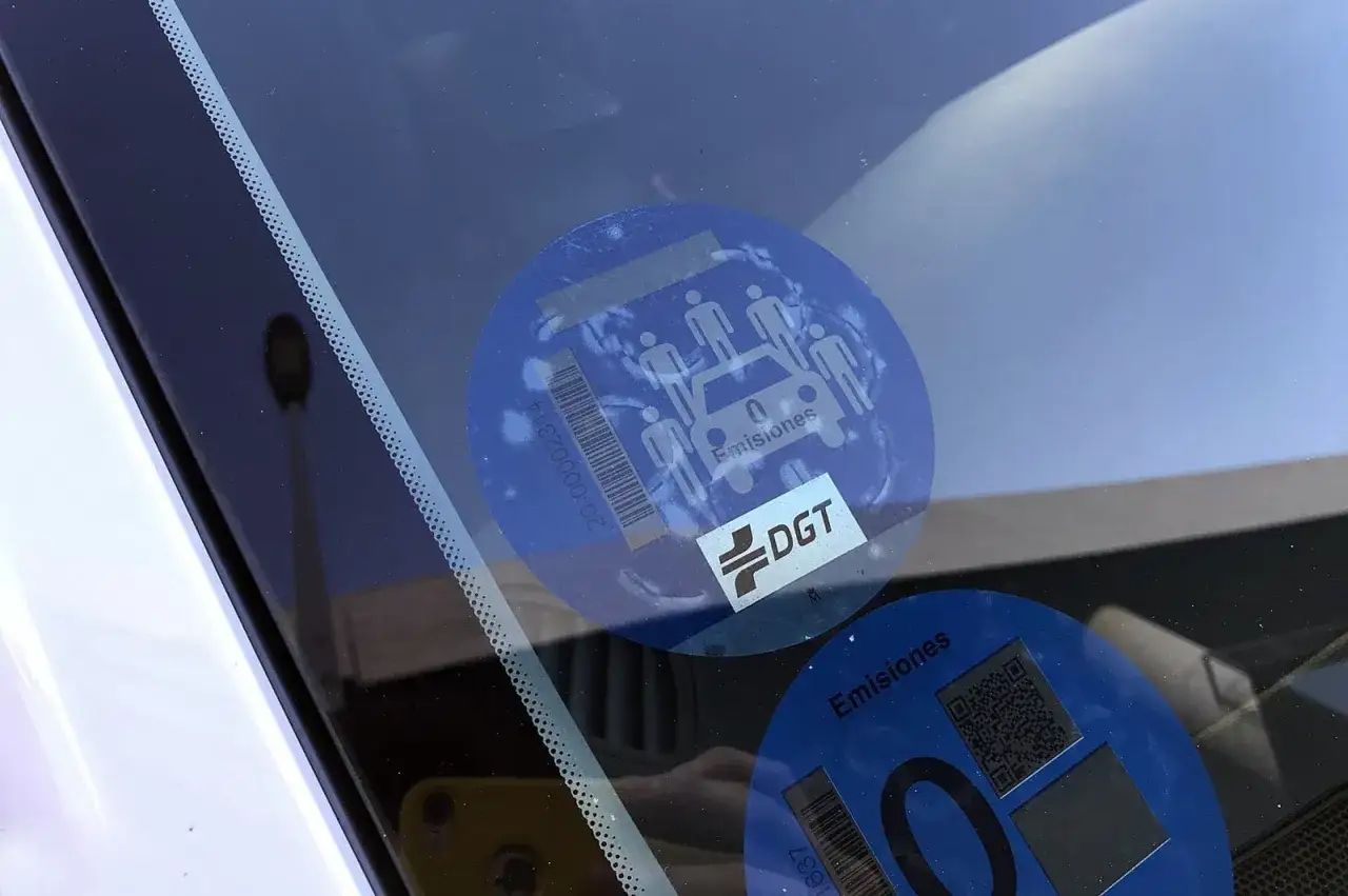 Pegatina de la DGT, señal v26, en el parabrisas. Indica bajas emisiones del vehículo.