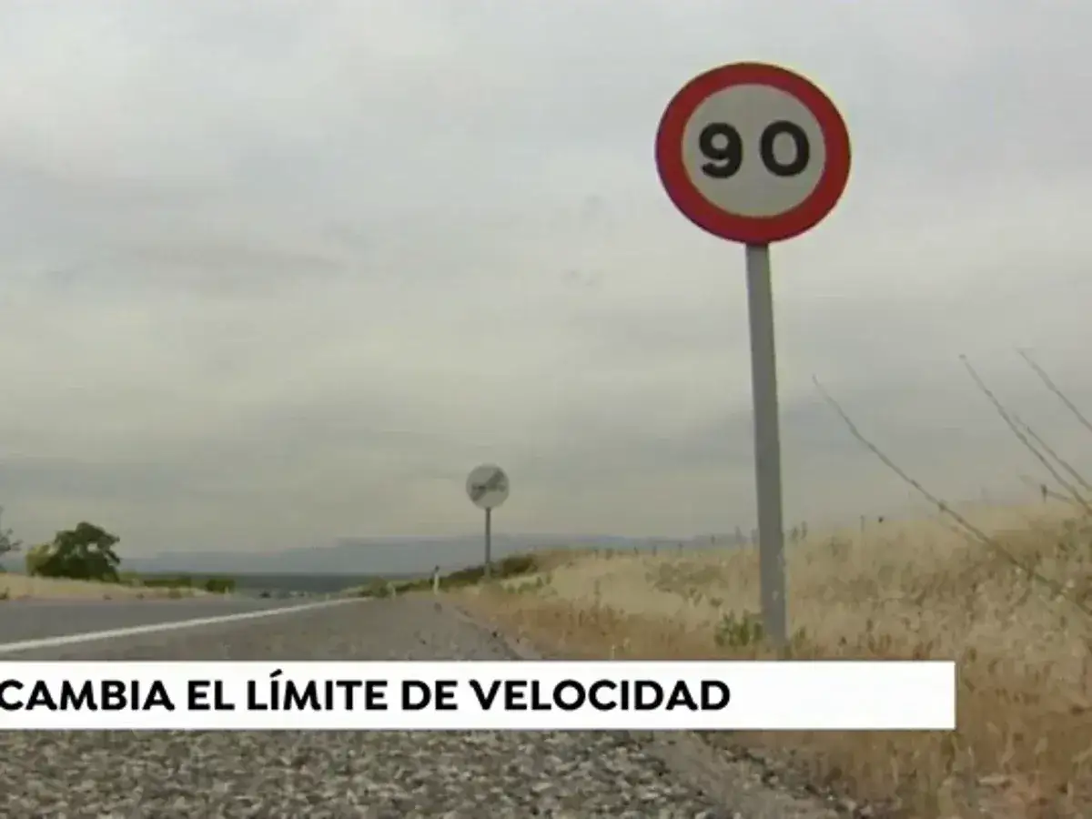 Señal de tráfico indica velocidad máxima de 90 km/h en carretera convencional. El paisaje es árido y el cielo nublado.