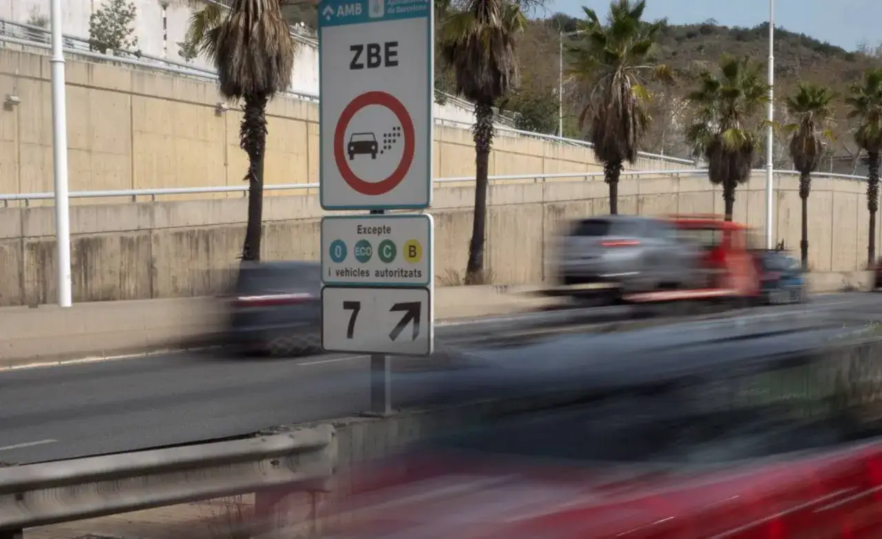 Se&ntilde;al r120 de Zona de Bajas Emisiones (ZBE) con excepciones para veh&iacute;culos ECO, C y B. Coches en movimiento.