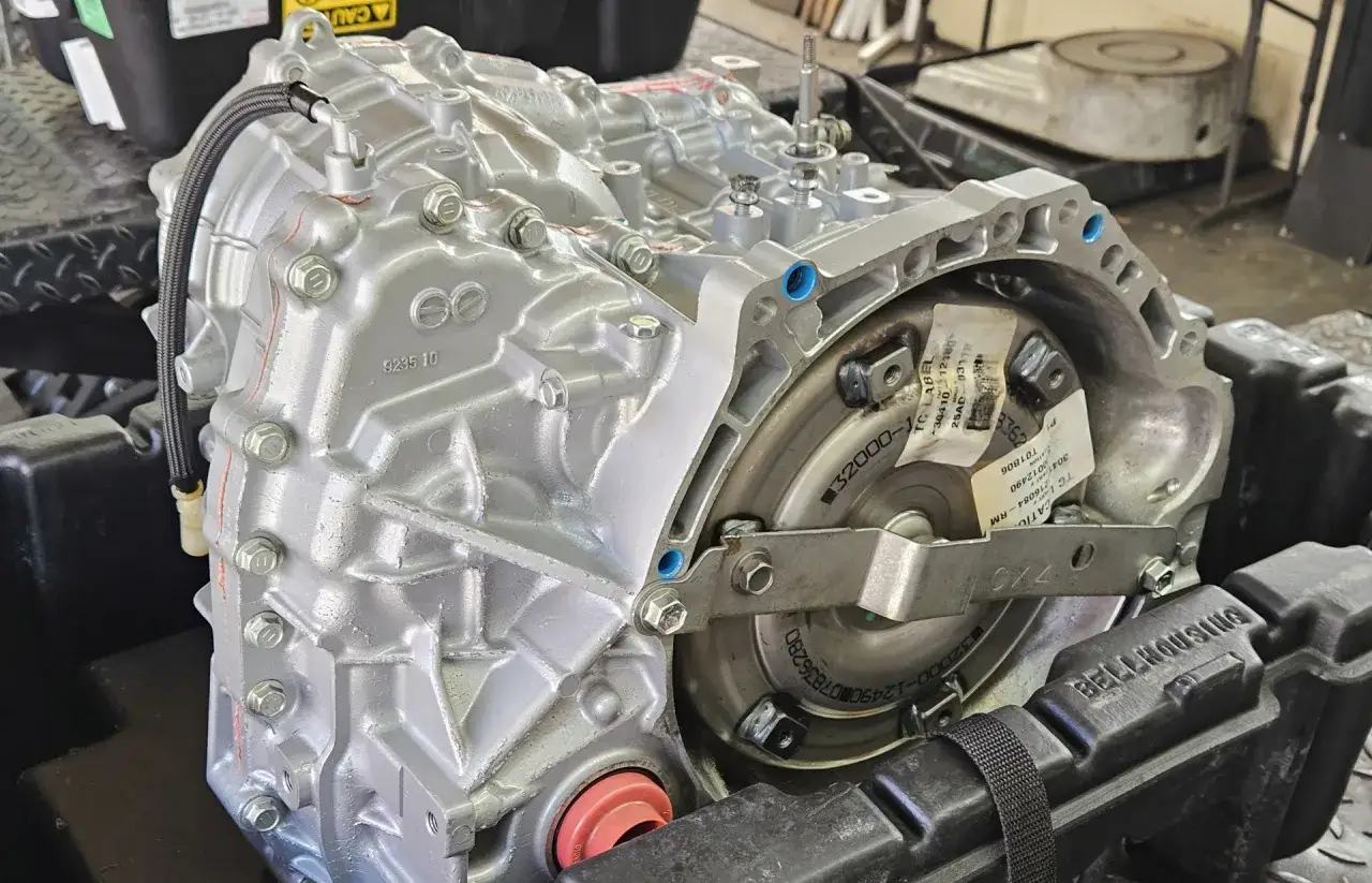 Transmisi&oacute;n autom&aacute;tica cambio cvt, plateada y con detalles de manguera negra.