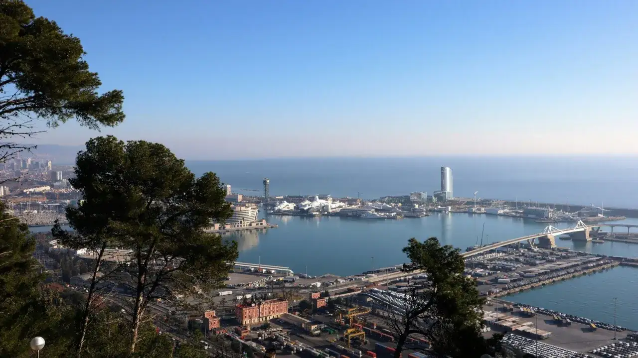Vista panorámica del puerto de Barcelona, con barcos, grúas y edificios modernos. El teleférico de Barcelona ofrece esta vista.